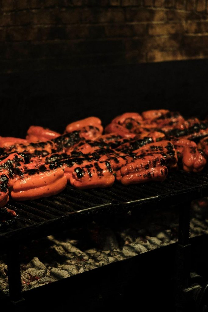 elkano peppers grilling over charcoal